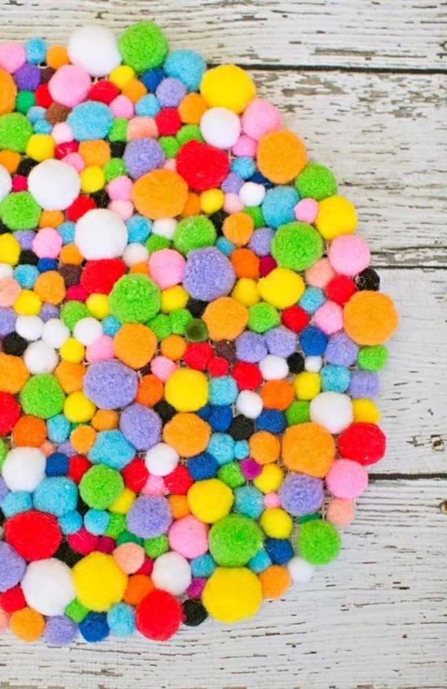Rainbow Pom-Poms On Weathered Wood