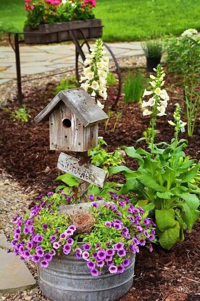 Weathered Birdhouse Among Blooming Petunias