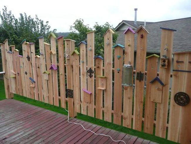 Colorful Birdhouses Line Fence