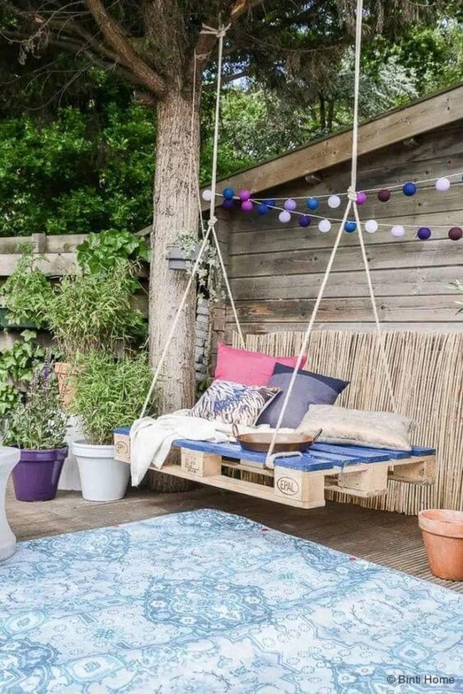 Suspended Wooden Bed Among Green Plants