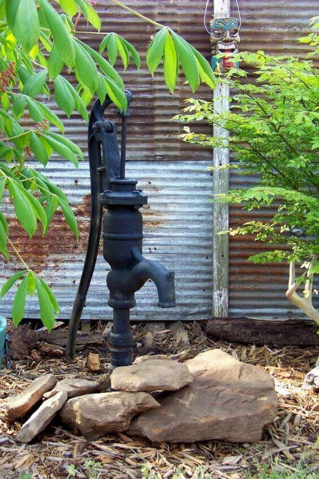 Black Iron Pump Among Stone