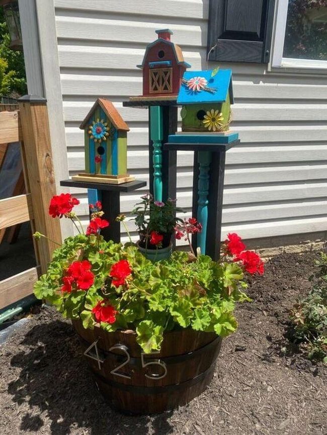 Painted Birdhouses Among Blooming Geraniums